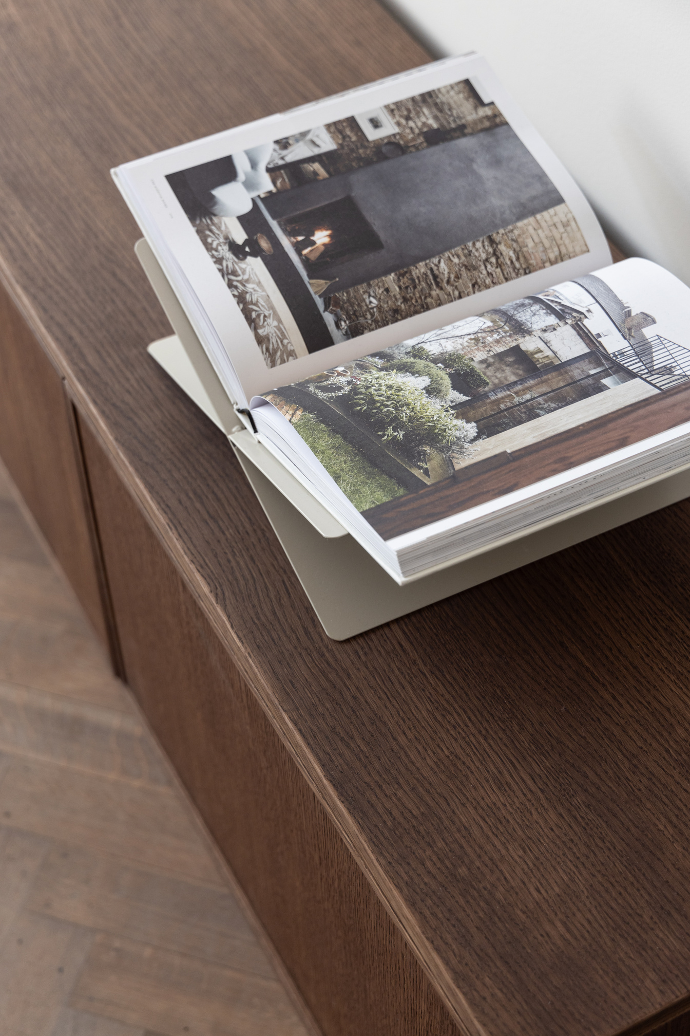 Opengeslagen interieurboek op een donker houten dressoir