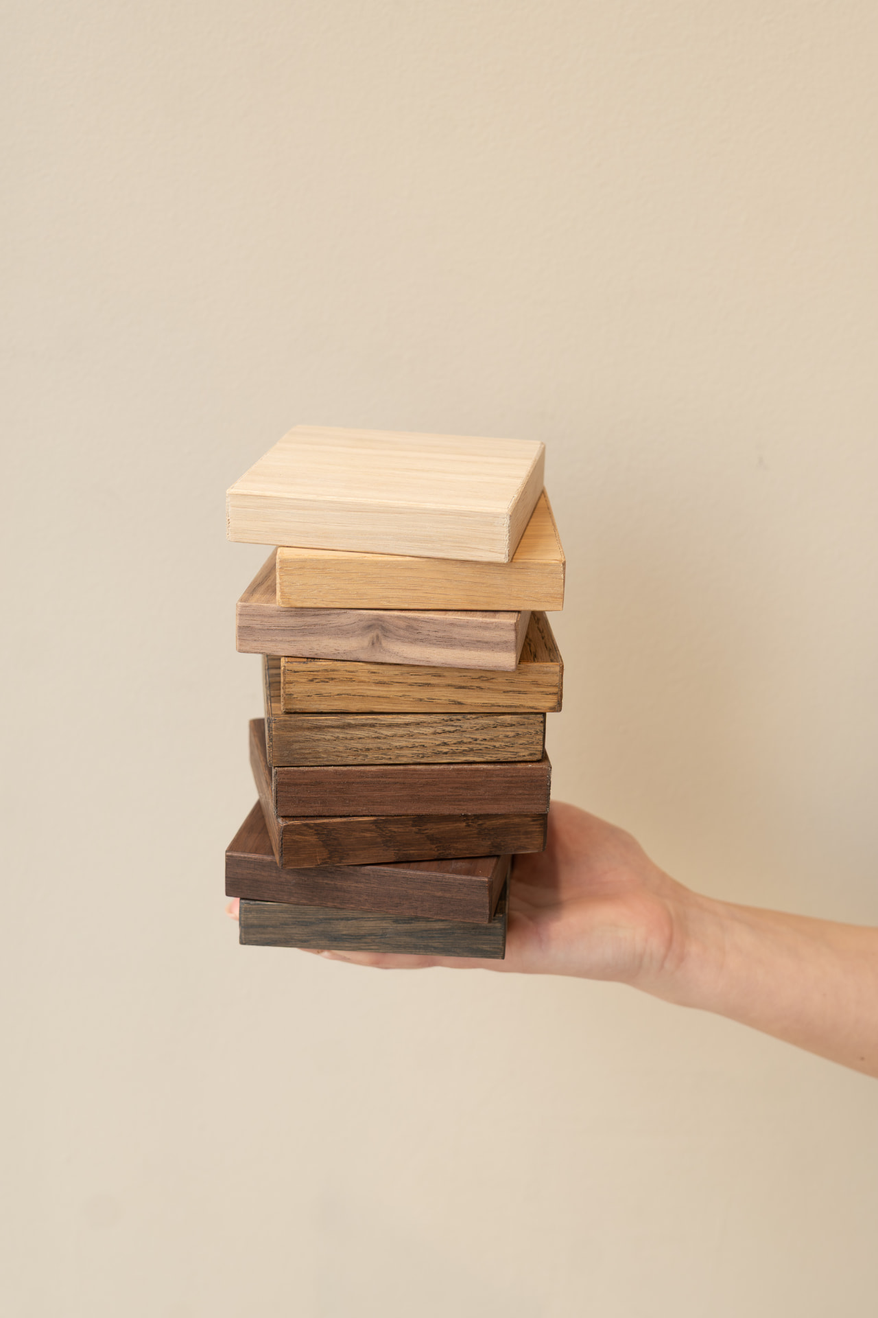 Hand met een stapel houten samples van Studio Fedde