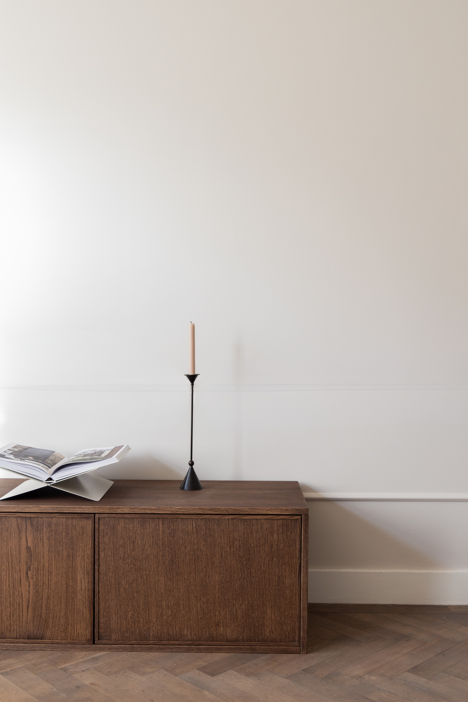 Donker houten dressoir met kaars en opengeslagen boek